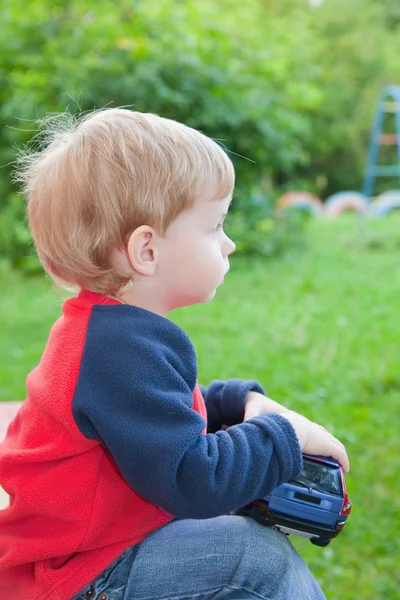 Child with toy car in park — Stock Photo, Image