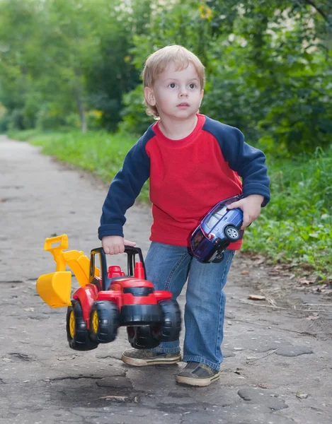Ребёнок играет с игрушечным грузовиком в парке — стоковое фото