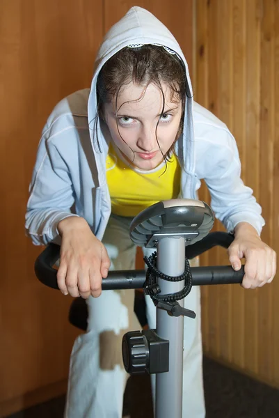 Weariness girl on exercycle — Stock Photo, Image