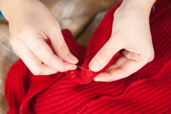 Mujer manos cosiendo un botón — Foto de Stock