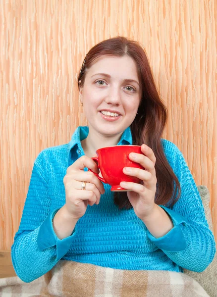 Kız evde kırmızı bir fincanla rahatlatıcı — Stok fotoğraf