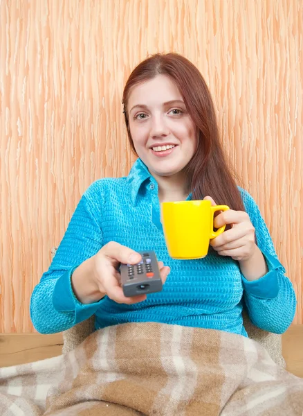 Žena s úsměvem s tv remote — Stock fotografie