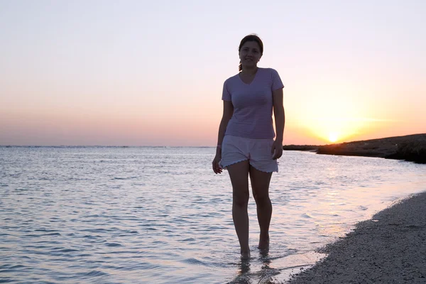 Meisje op Zeekust tijdens zonsopgang — Stockfoto