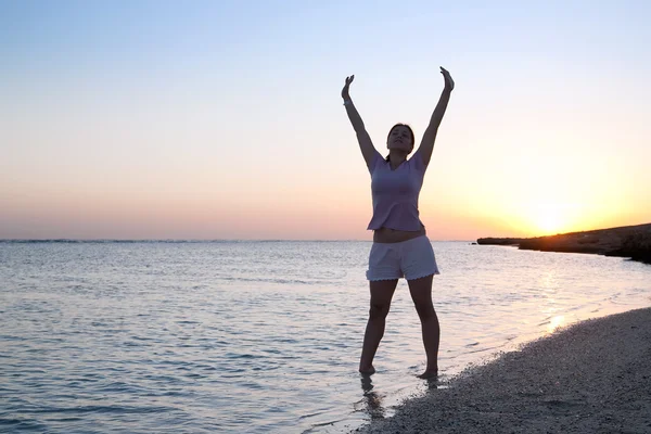 Девушка на берегу моря во время восхода солнца — стоковое фото