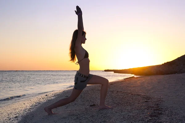 Dívka praktikování jógy proti západu slunce — Stock fotografie