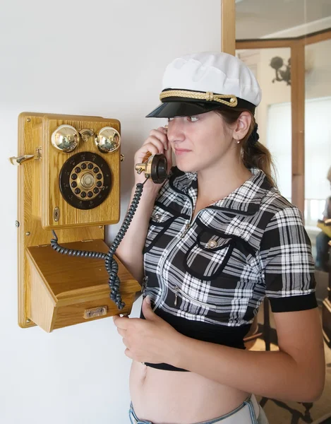 Chica está hablando por teléfono de madera retro — Foto de Stock