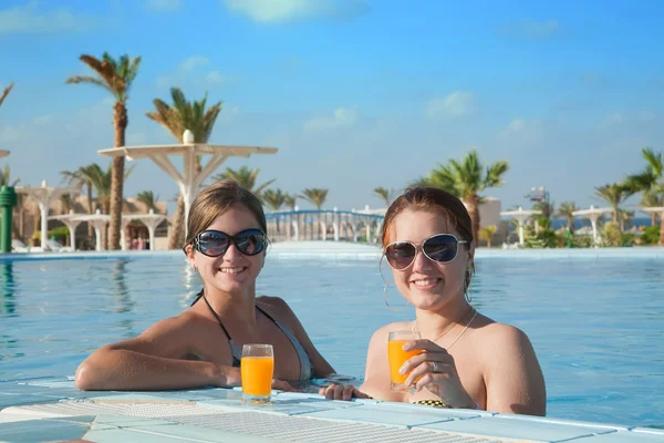 Girls with orange juice at resort hotel — Stock Photo, Image