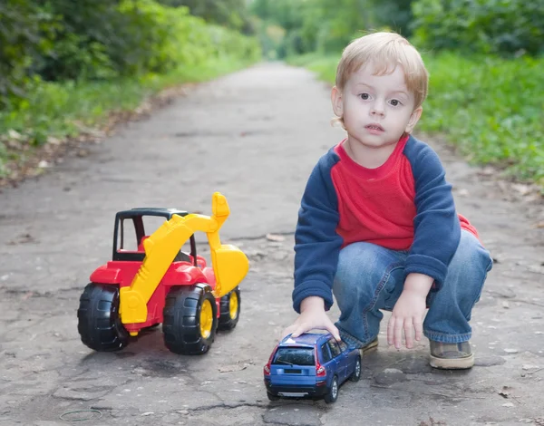 Ребенок играет в игрушечную машину в парке — стоковое фото