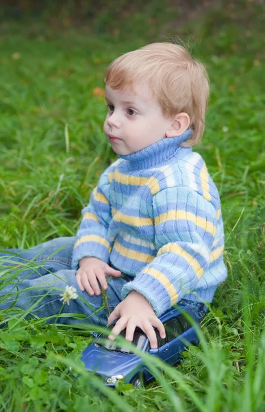 公園の芝生の上に座っている小さな男の子 — ストック写真