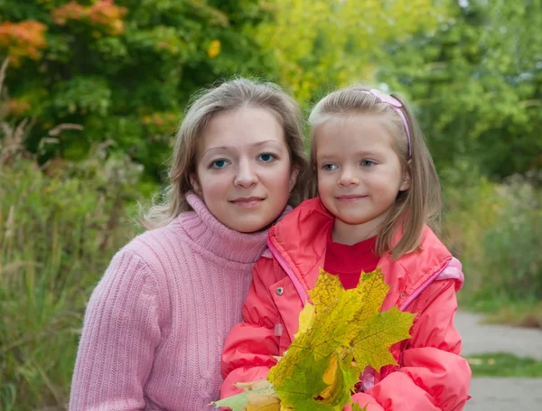 Vrouw met dochter in de herfst — Stockfoto