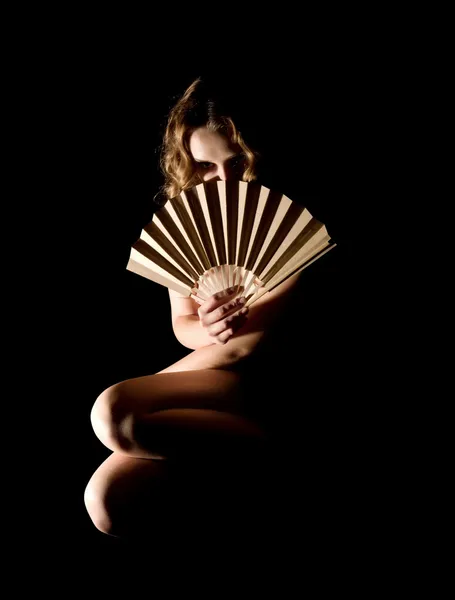 Девушка с вентилятором на черном — стоковое фото