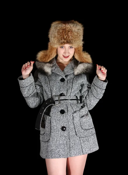 Gilr in coat and fox cap on black — Stock Photo, Image