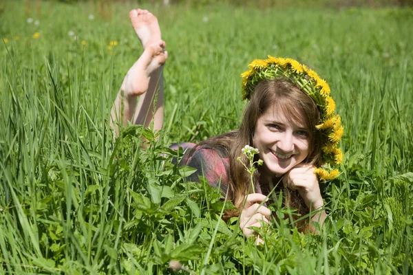 Girl in a chaplet lying from meadow — Stock Photo, Image