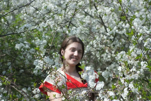 Menina sorridente em um jardim de primavera — Fotografia de Stock