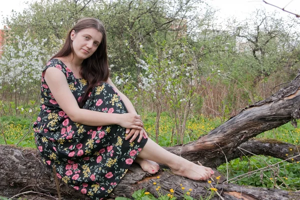 春の庭に座っている女の子 — ストック写真