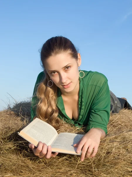Dívka čtení na čerstvé seno — Stock fotografie