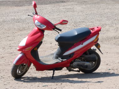 Red new scooter on road from summer clipart