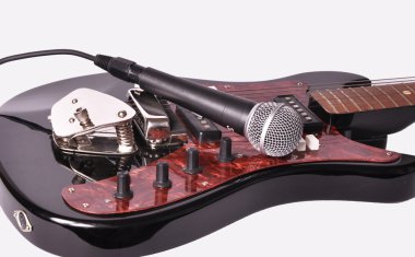 bir gitar üzerinde yatan bir mikrofon