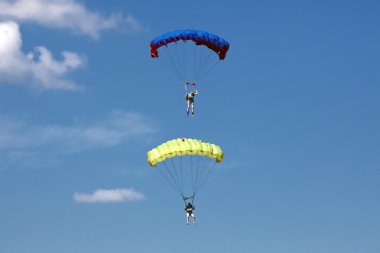 Parachutists in the dark blue sky clipart