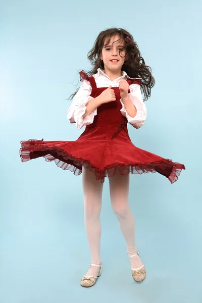 Dziewczynka w czerwonej sukience przędzenia — Zdjęcie stockowe