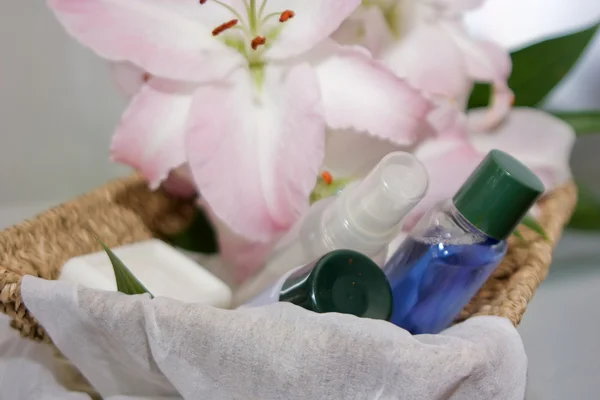 Toiletries in basket and pink lily — Stock Photo, Image