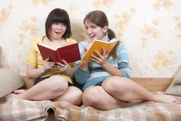 Dvě dívky čtení na pohovce — Stock fotografie