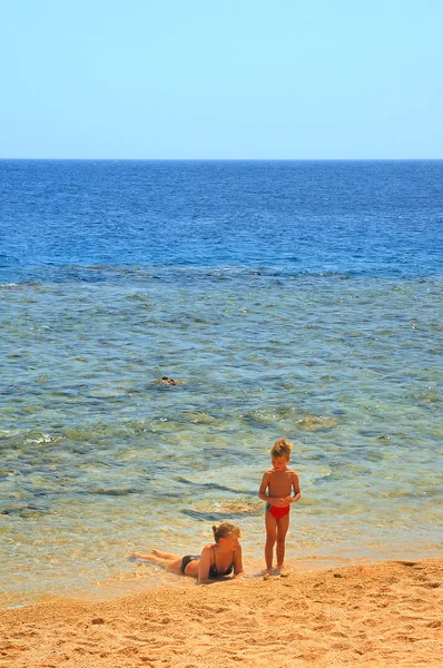 Ma e figlio giocare su spiaggia su backgroun — Foto Stock