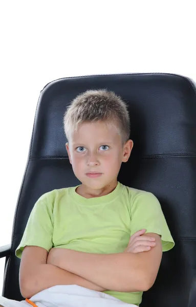 Çocuk oturmak sandalye ve kamera bakmak — Stok fotoğraf