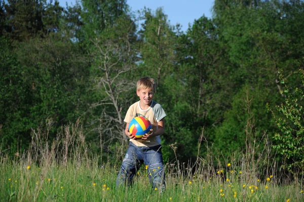 Liten pojke med en boll i parken — Stockfoto