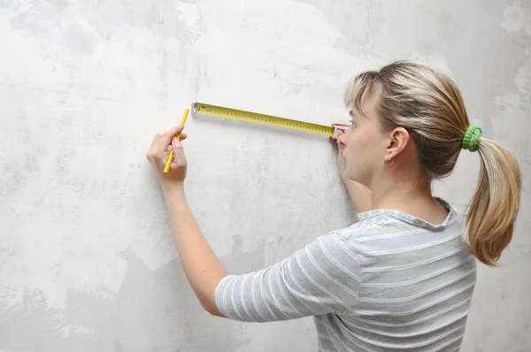 stock image Worker woman measuring on wall