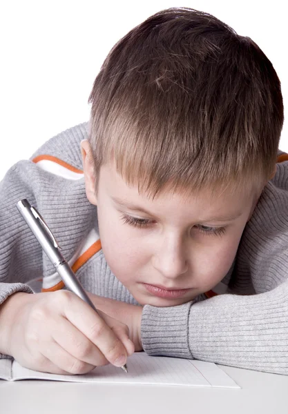 Junge zeichnet ein Bleistiftbild liegend — Stockfoto