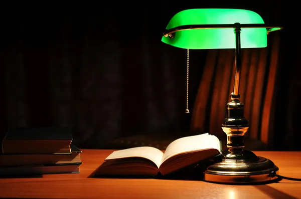 Lámpara de mesa verde y libro abierto — Foto de Stock