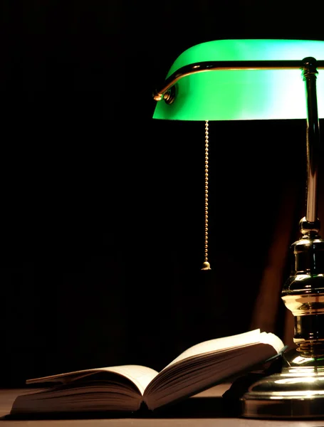 Electric green lamp and opened book — Stok fotoğraf