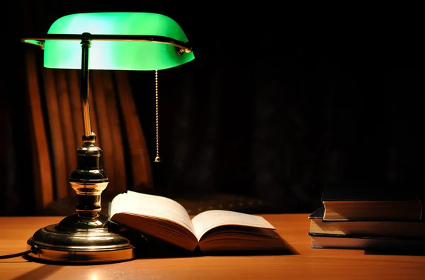 Zelený stolní lampu a otevřenou knihu — Stock fotografie