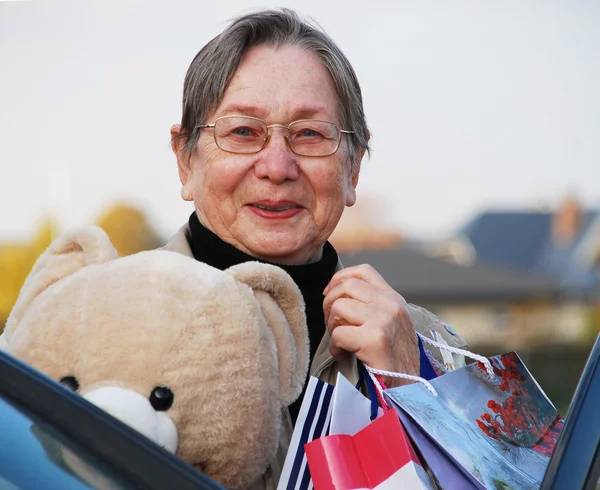 Mormor med armar full av gåvor — Stockfoto