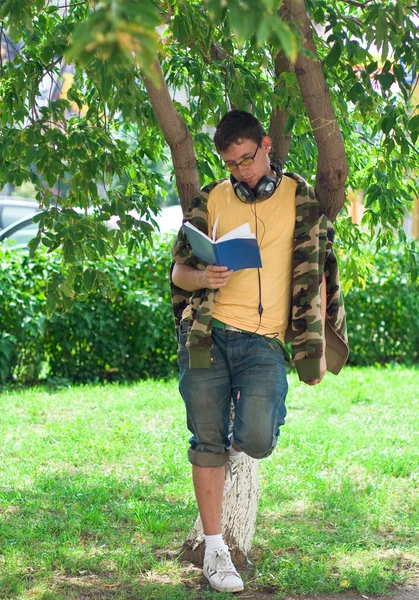 stock image Man reading book under the tree