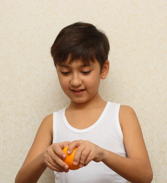 Chłopiec, obieranie pomarańczy — Zdjęcie stockowe