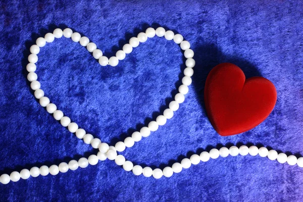 Κόκκινη καρδιά και μαργαριταρένια neacklace στο μπλε v — Φωτογραφία Αρχείου
