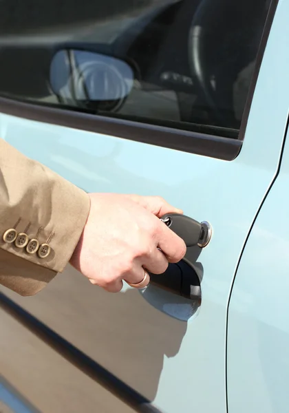 stock image Men hand with key open car door