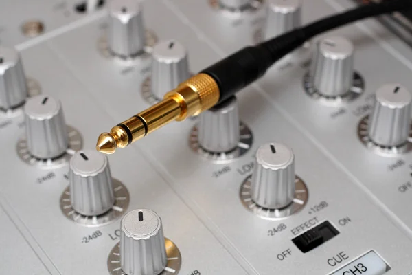 Gold plug on dj music mixer — Stock Photo, Image