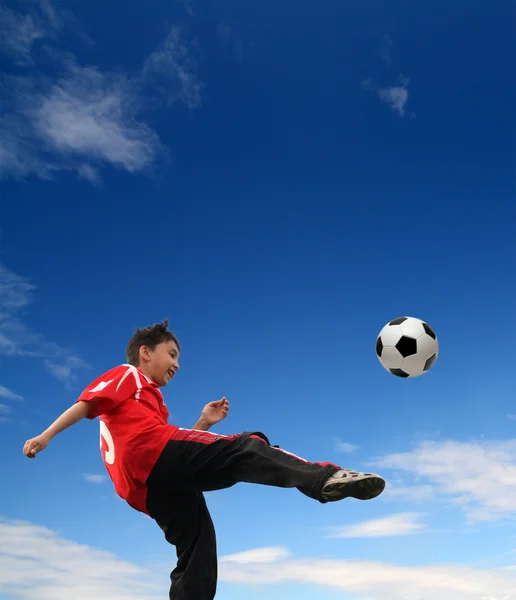 Азиатский мальчик играет в футбол — стоковое фото