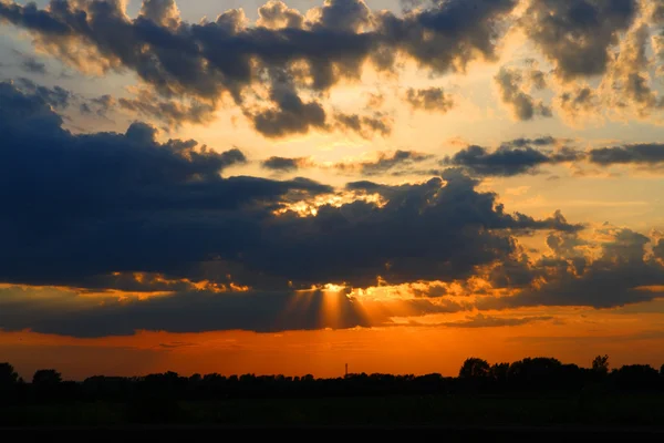 Solen bakom mörka moln i himlen — Stockfoto