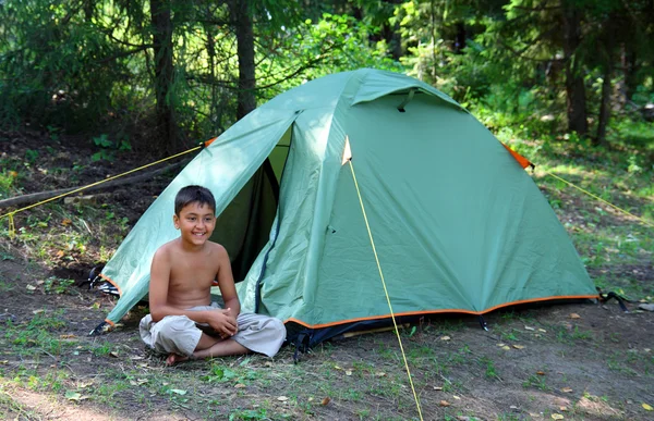 Rapaz sorridente perto da tenda — Fotografia de Stock