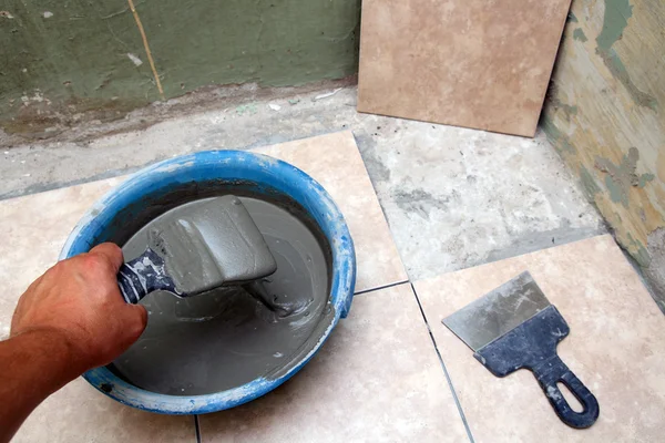 stock image Worker laying ceramicson floor