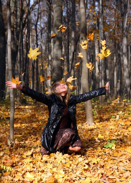 Menina bonita vomitando folhas de outono — Fotografia de Stock