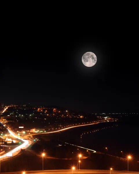 Lua sobre estradas noturnas e aterro — Fotografia de Stock