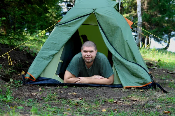 Большой улыбающийся мужчина в палатке для кемпинга — стоковое фото