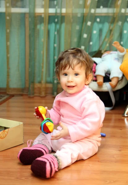 Menina bebê com brinquedo no chão — Fotografia de Stock