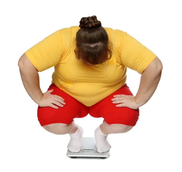 Overweight women on scales Royalty Free Stock Photos