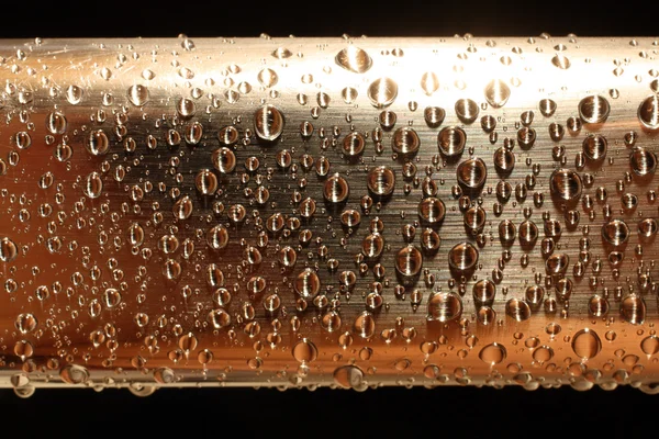 Waterdruppels op gouden metal — Stockfoto